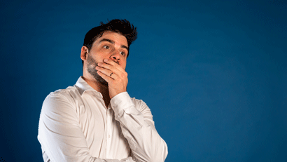 Young male teacher looking anxious and thoughtful against blue background