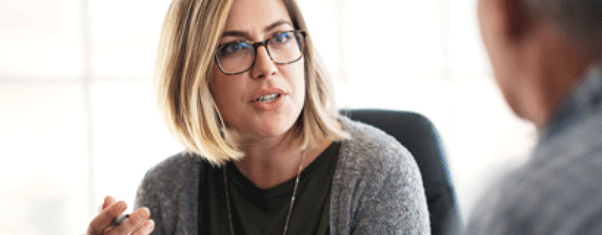 Female teacher in discussion with male colleague.