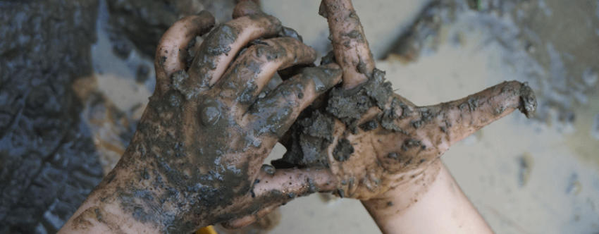 Close-up of child's muddy hands