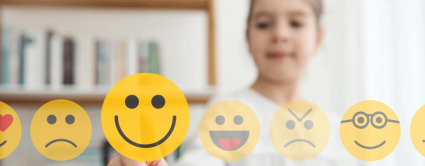 Young girl choosing selecting a happy icon from a range of emojis.